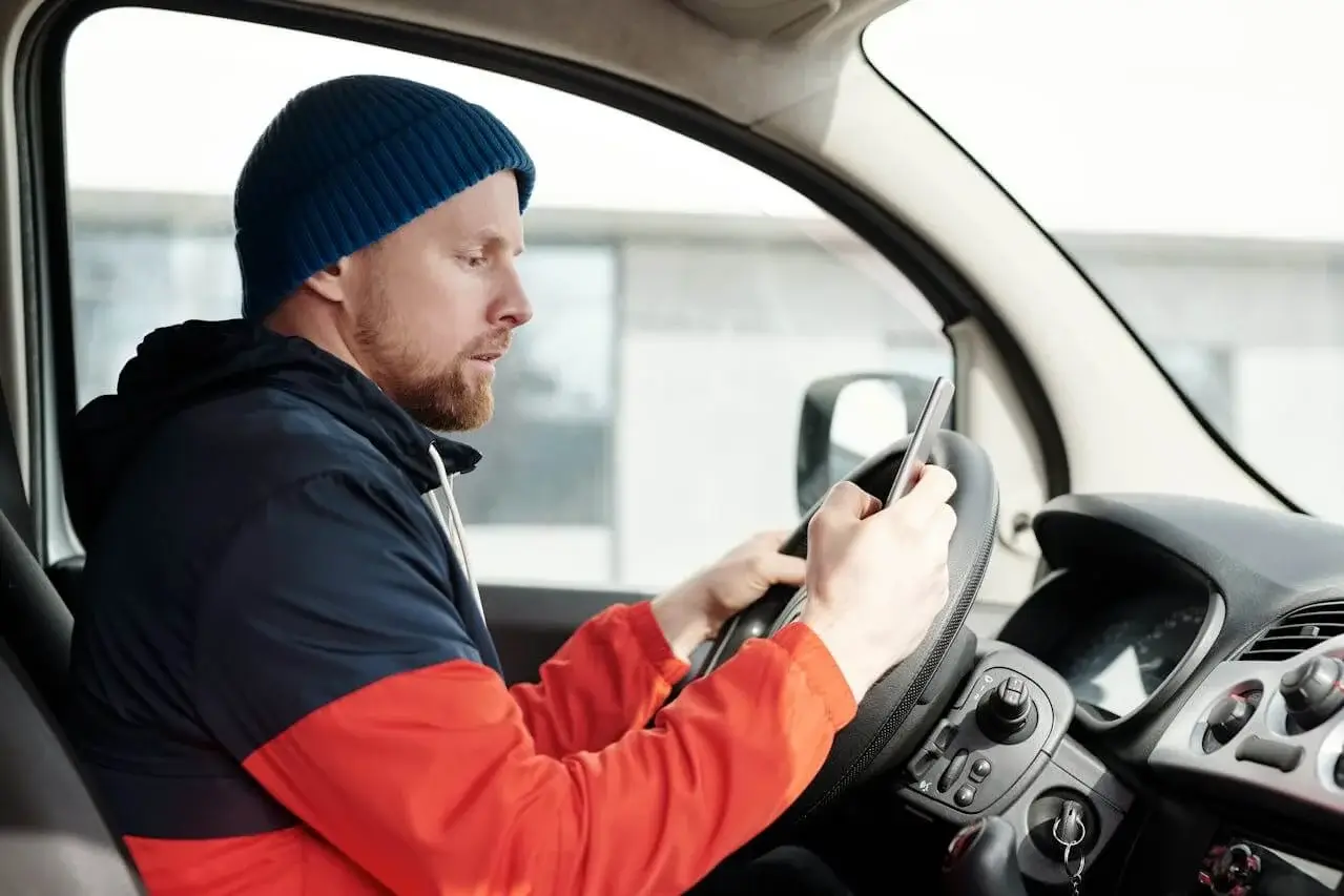 a man checking up his phone while inside the car