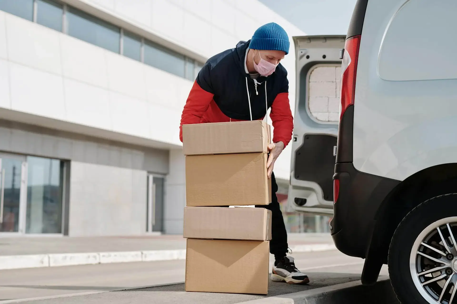 a man puts boxes inside in the van